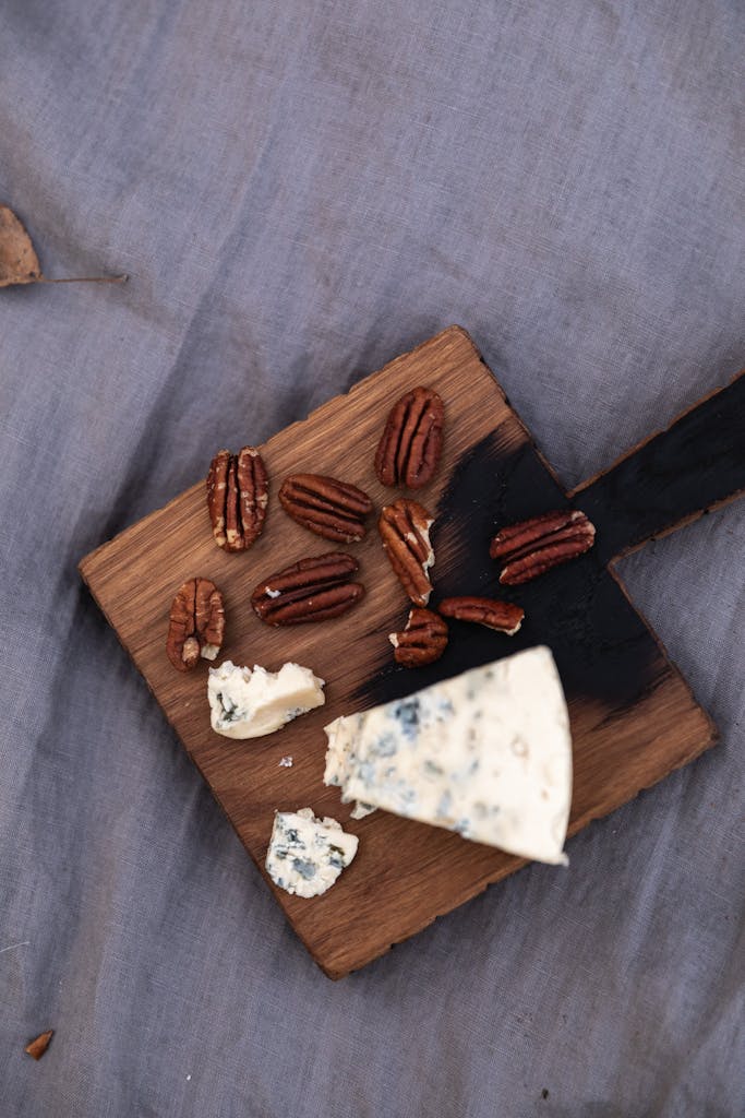 A stylish arrangement of blue cheese and pecans on a wooden cutting board for a gourmet touch.