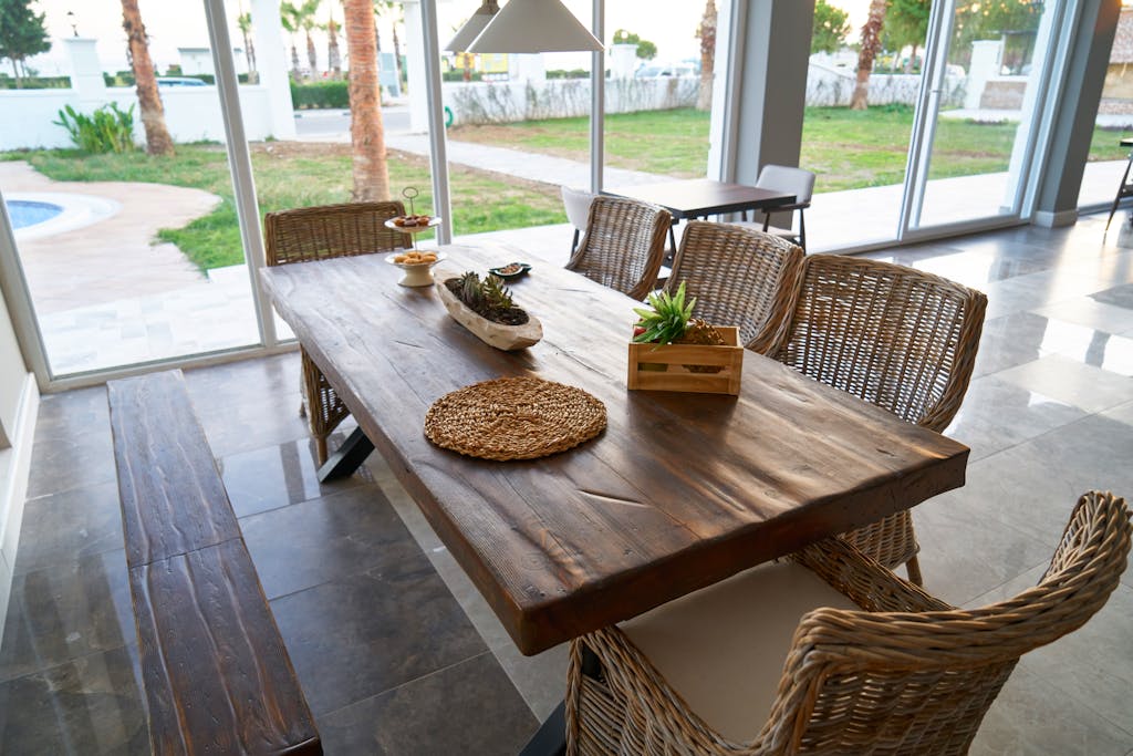 Cozy indoor dining area with rustic wooden table and wicker chairs, offering a warm and inviting atmosphere.