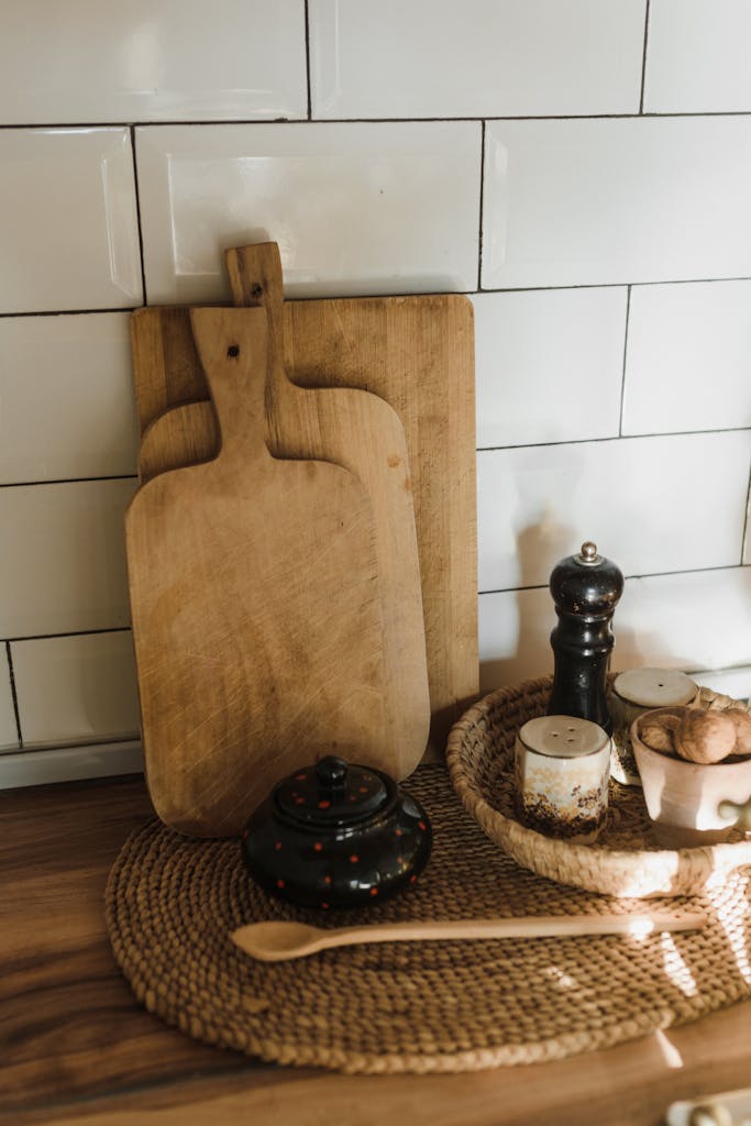 Cozy rustic kitchen arrangement featuring wooden cutting boards, a pepper mill, and natural decor.