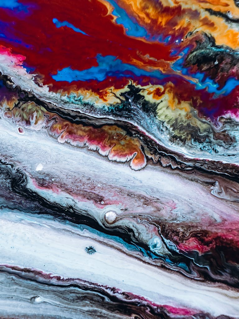 Dynamic and colorful abstract art created with acrylic pouring technique, showcasing vivid swirls and patterns.