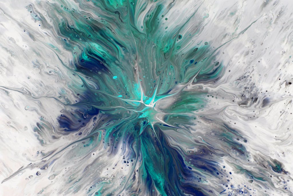 Dynamic fluid art with turquoise and white, resembling waves or nature's patterns.