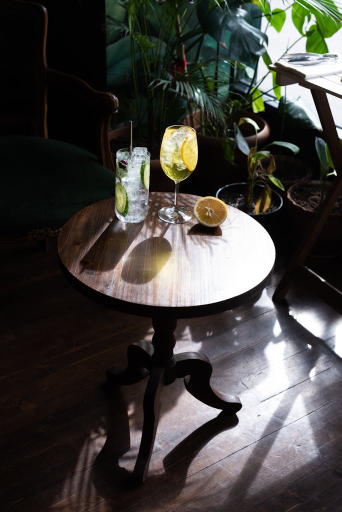 Lemon and cucumber drinks on a wooden table in indoor setting with natural light.