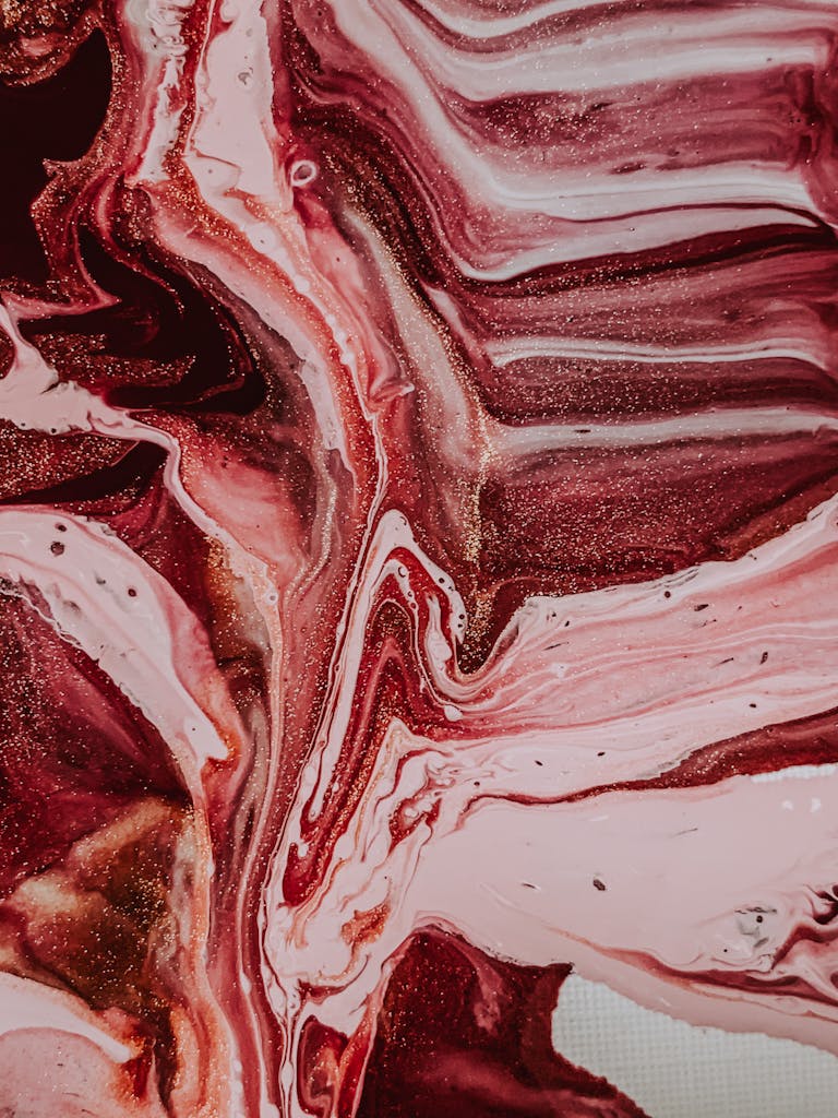 Top view of shiny surface of smeared wet acrylic dyes mixed and formed abstract background