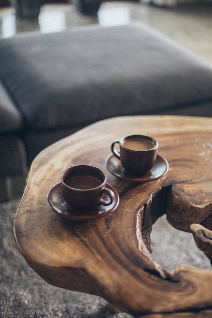 Two coffee cups on a rustic wooden table create a warm, inviting atmosphere.
